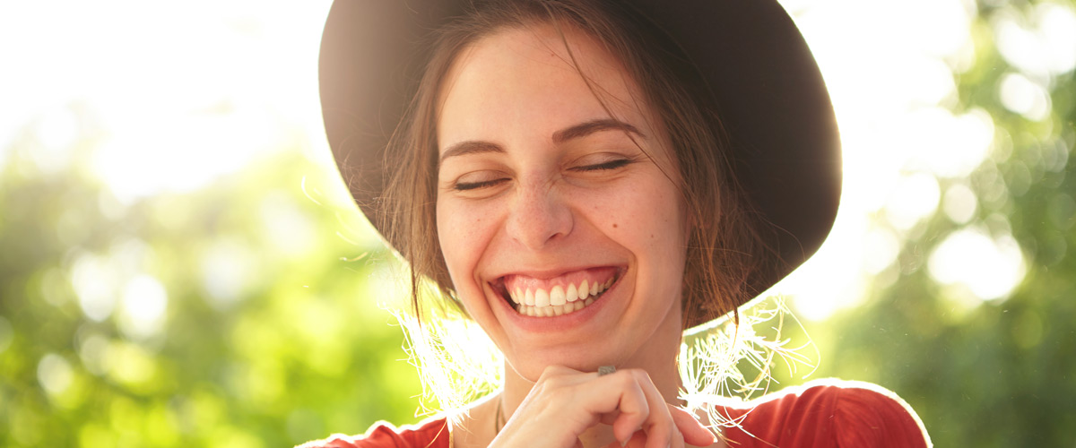 Woman wearing hat outside smiling